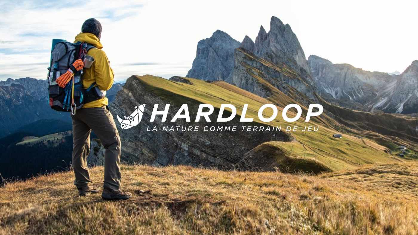 Hardloop — un randonneur face aux montagnes, avec le logo de l'enseigne