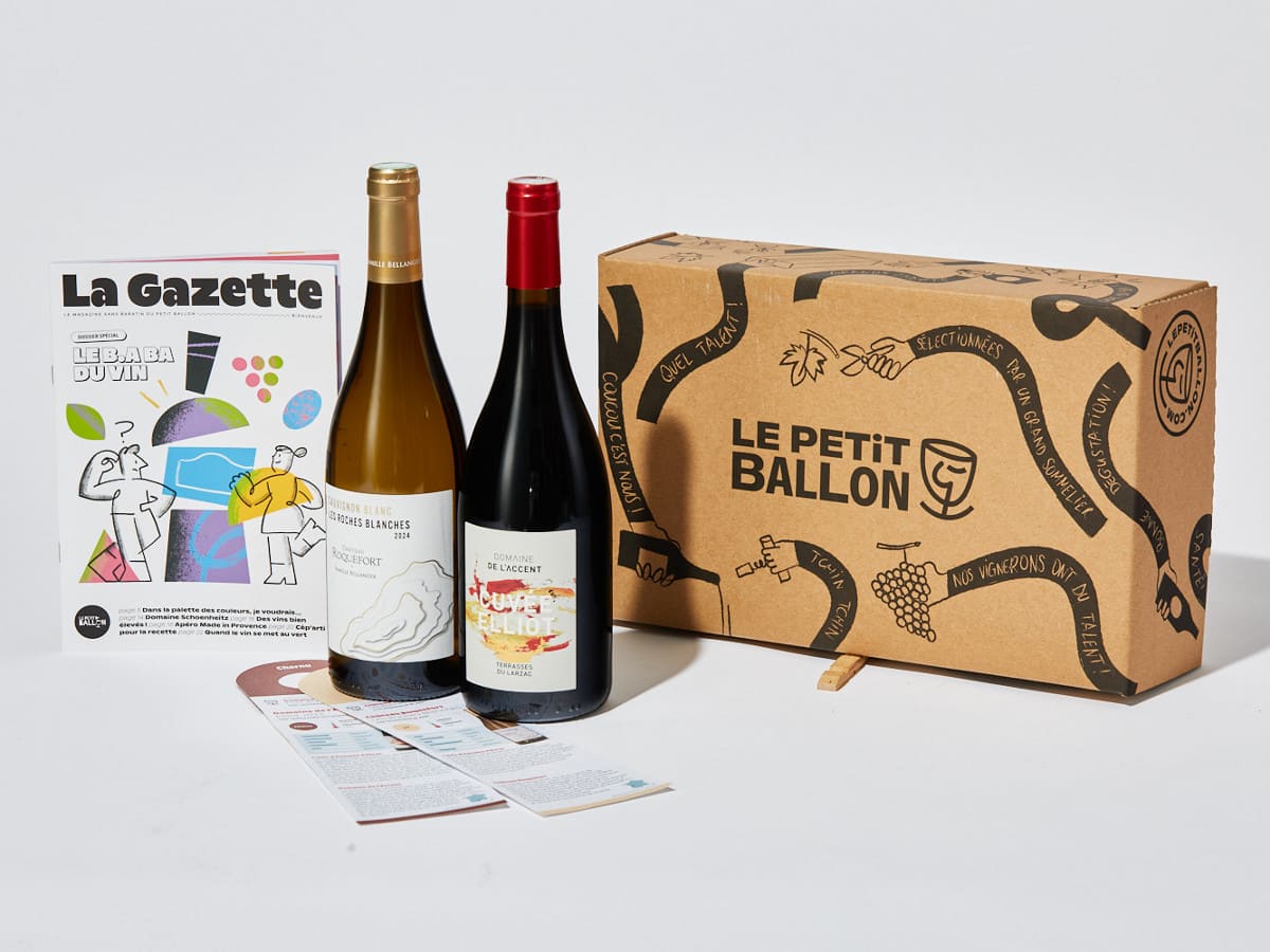 Une box Le Petit Ballon ouverte à côté de deux bouteilles de vin et du magazine La Gazette