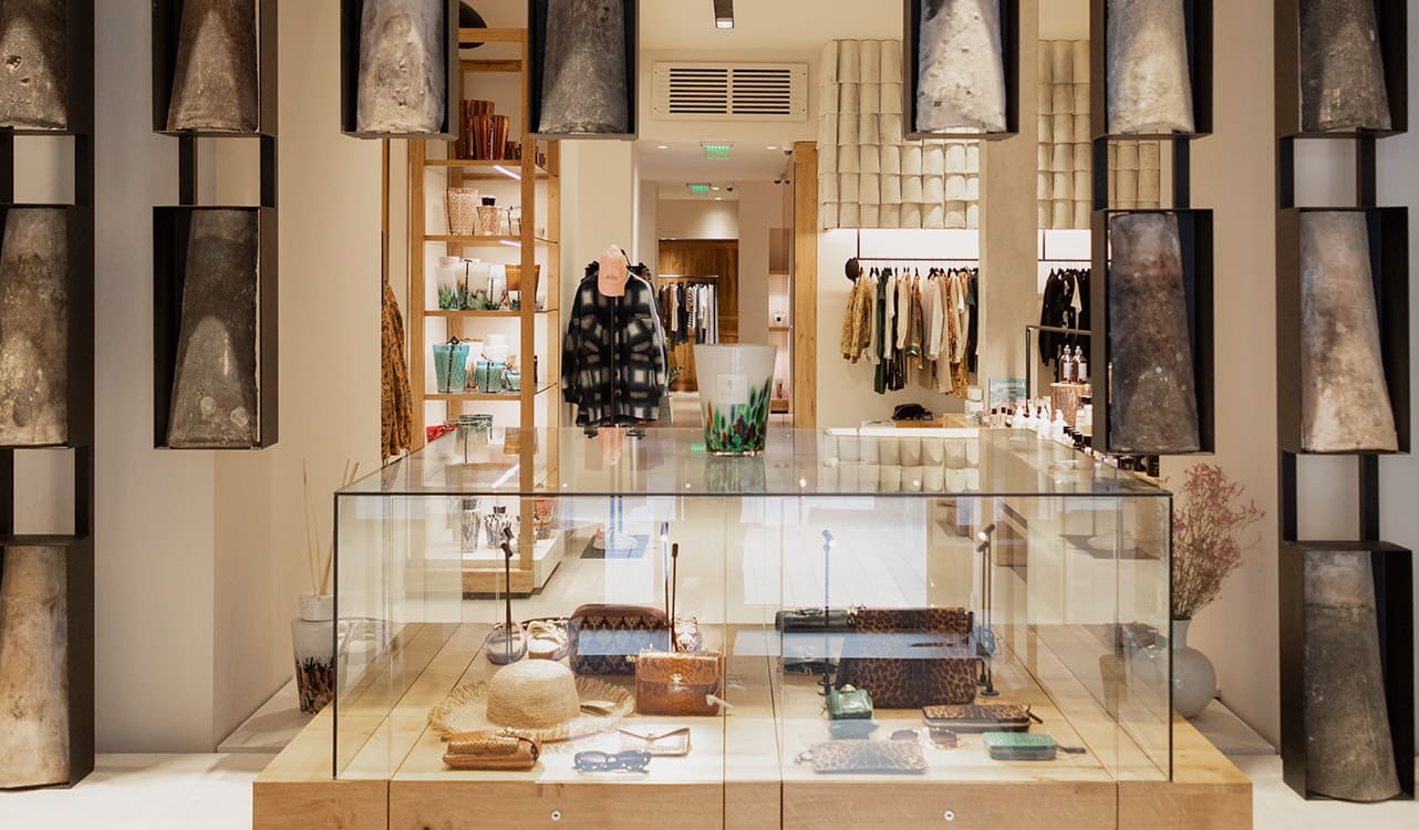 L'intérieur d'une boutique Lulli sur la Toile : une étoile lumineuse en bois clair devant les portants de vêtements